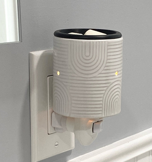 Art Deco wax warmer plugged into outlet.