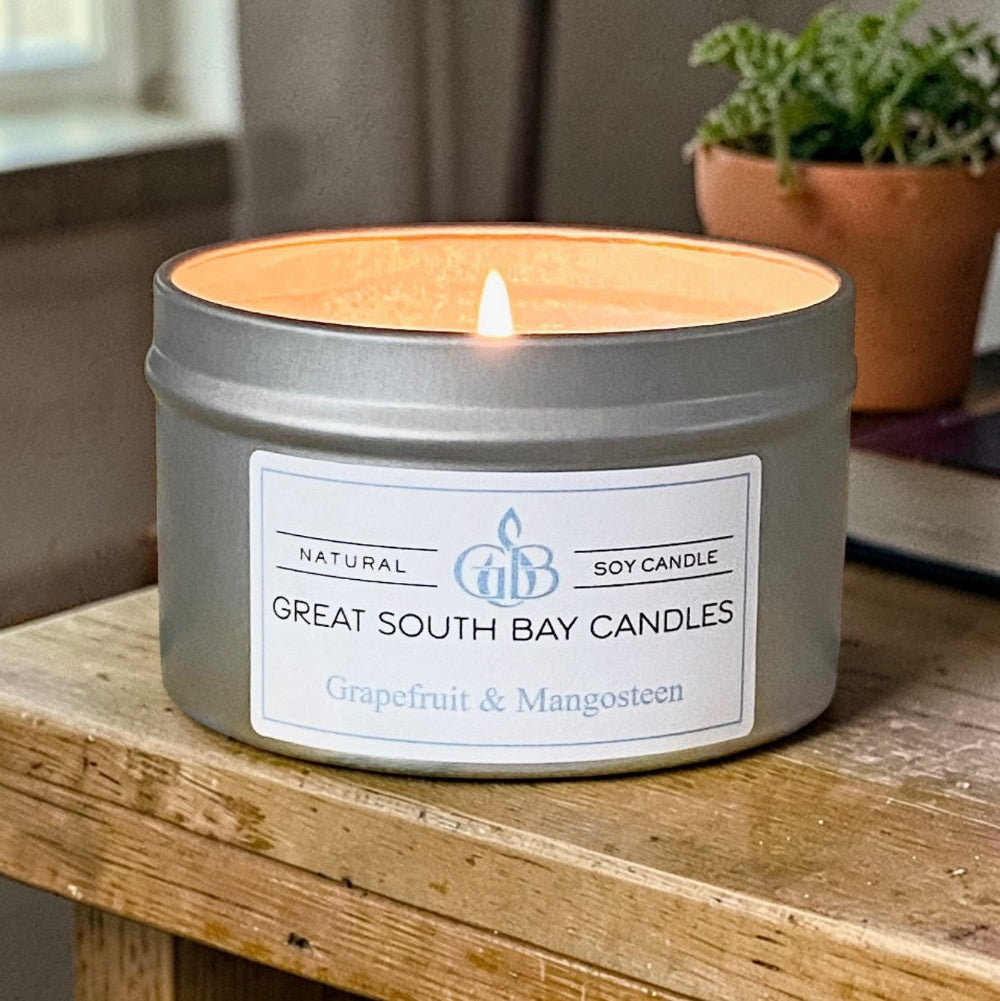 Grapefruit Mangosteen tin candle on a wooden table in a living room.
