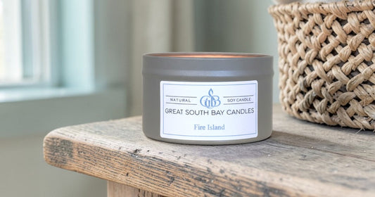 Fire Island scented candle on a wooden table with a basket.
