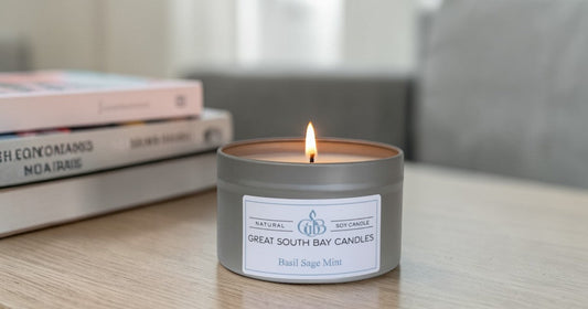 Basil sage mint candle on a wooden table with books.