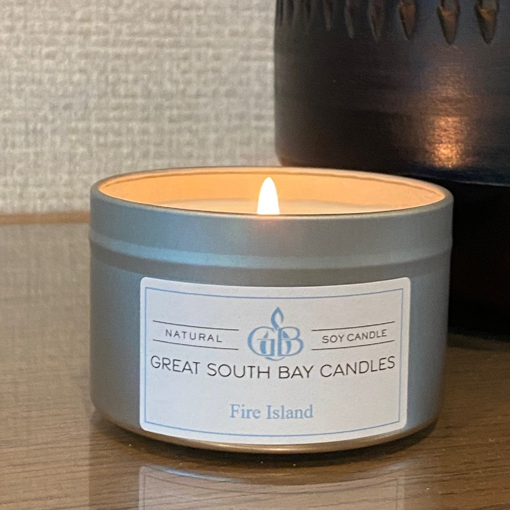 Fire Island travel tin candle from Great South Bay Candles a wooden surface.