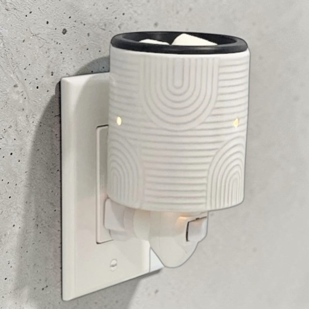 Art Deco pluggable candle wax warmer on a wall.
