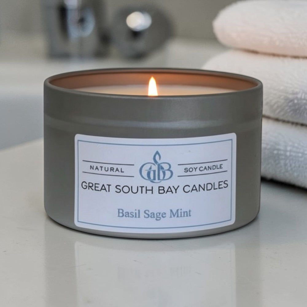 Candle in a silver tin with a label on a bathroom counter, featuring Great South Bay Candles.