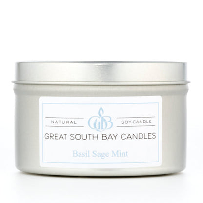 Candle in a silver metal tin on a white background.