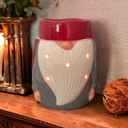 Ceramic Gnome candle wax warmer on a wooden surface with decorative items in the background.