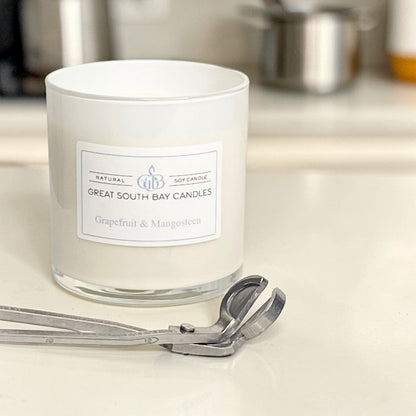 Grapefruit and Mangosteen scented candle on a kitchen counter with a wick trimmer.