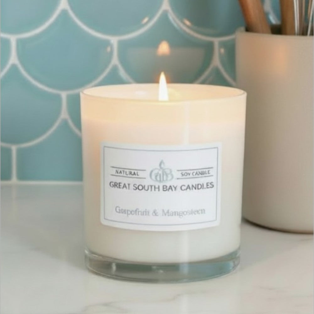 Grapefruit candle lit on a white kitchen countertop.