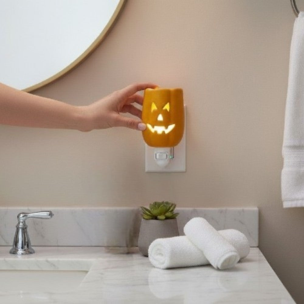 Person turning on a Halloween themed plug in candle wax warmer.
