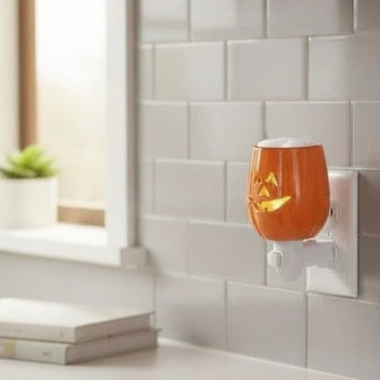 Jak O Lantern wax warmer plugged into a kitchen backsplash.
