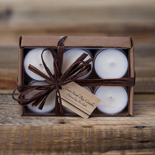 Set of 12 white unscented soy wax tea lights in a brown bow with brown raffia ribbon.