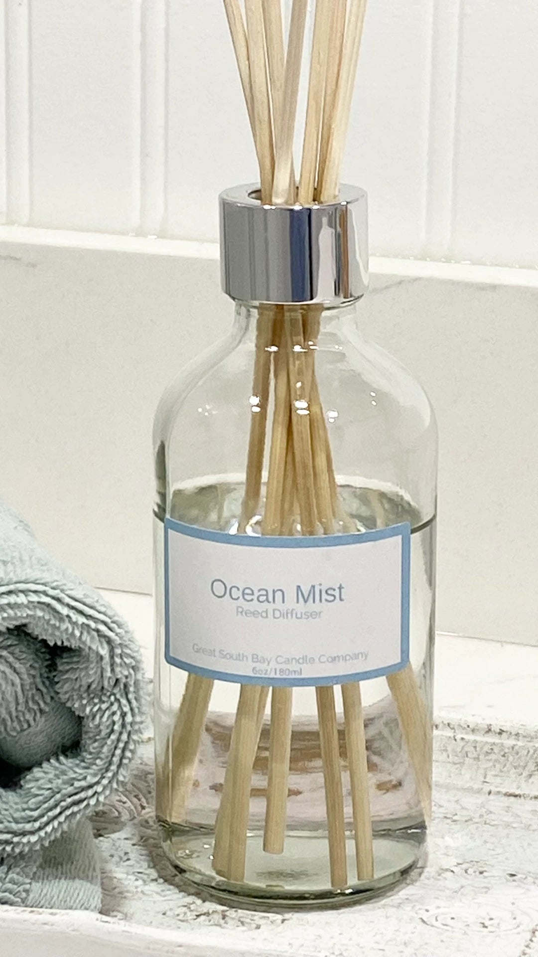 Ocean Mist Diffuser with reeds on bathroom sink.