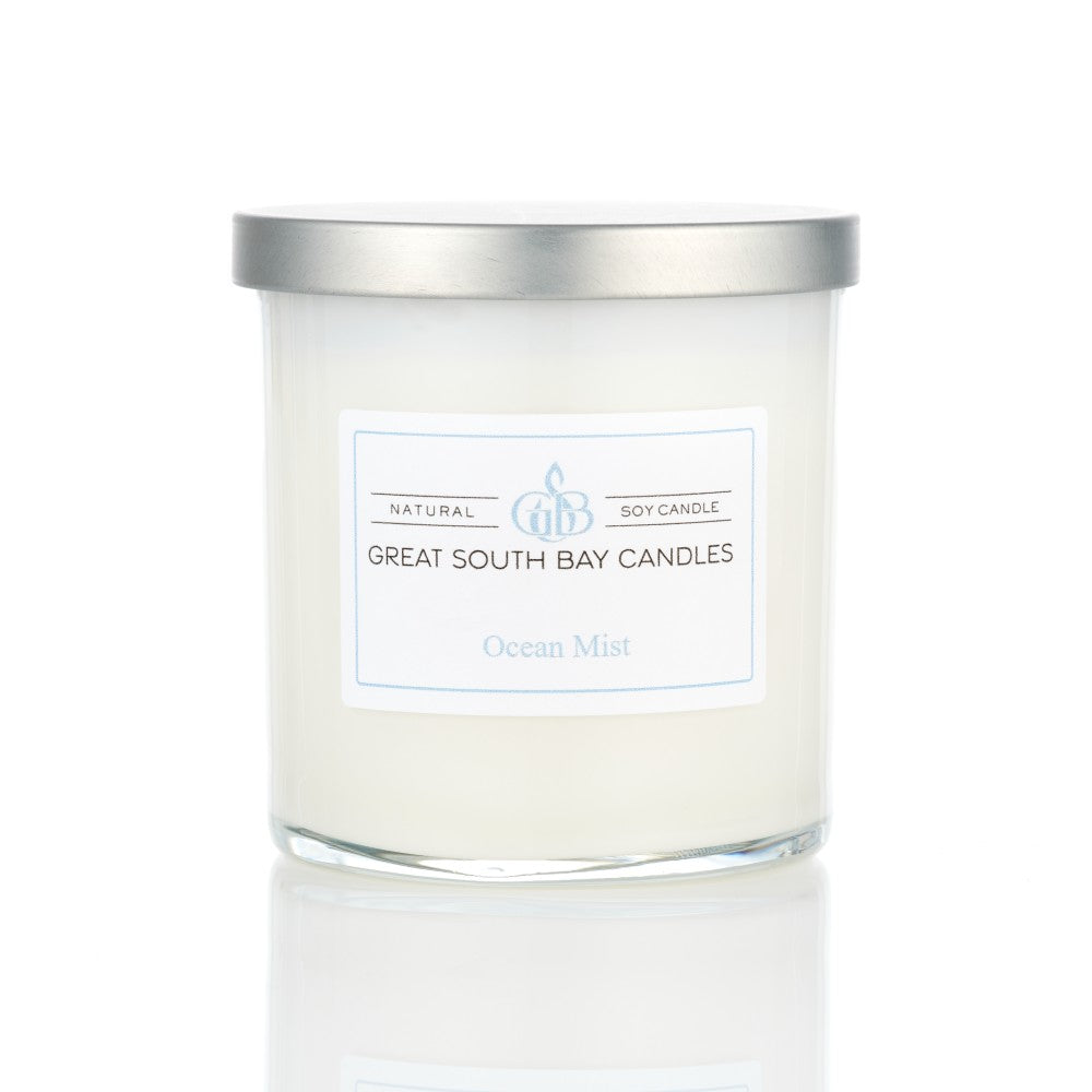 Ocean Mist tropical scented candle in a glass tumbler, with a silver lid on a white background.