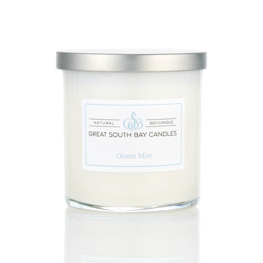 Ocean Mist tropical scented candle in a glass tumbler, with a silver lid on a white background.