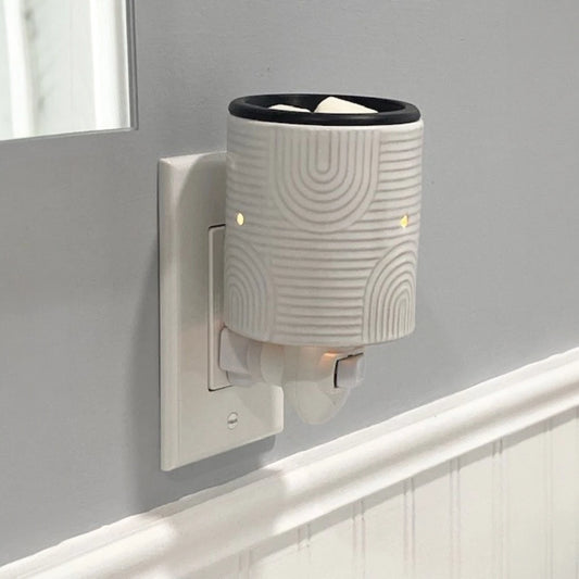 Wall mounted candle wax warmer in a bathroom. 