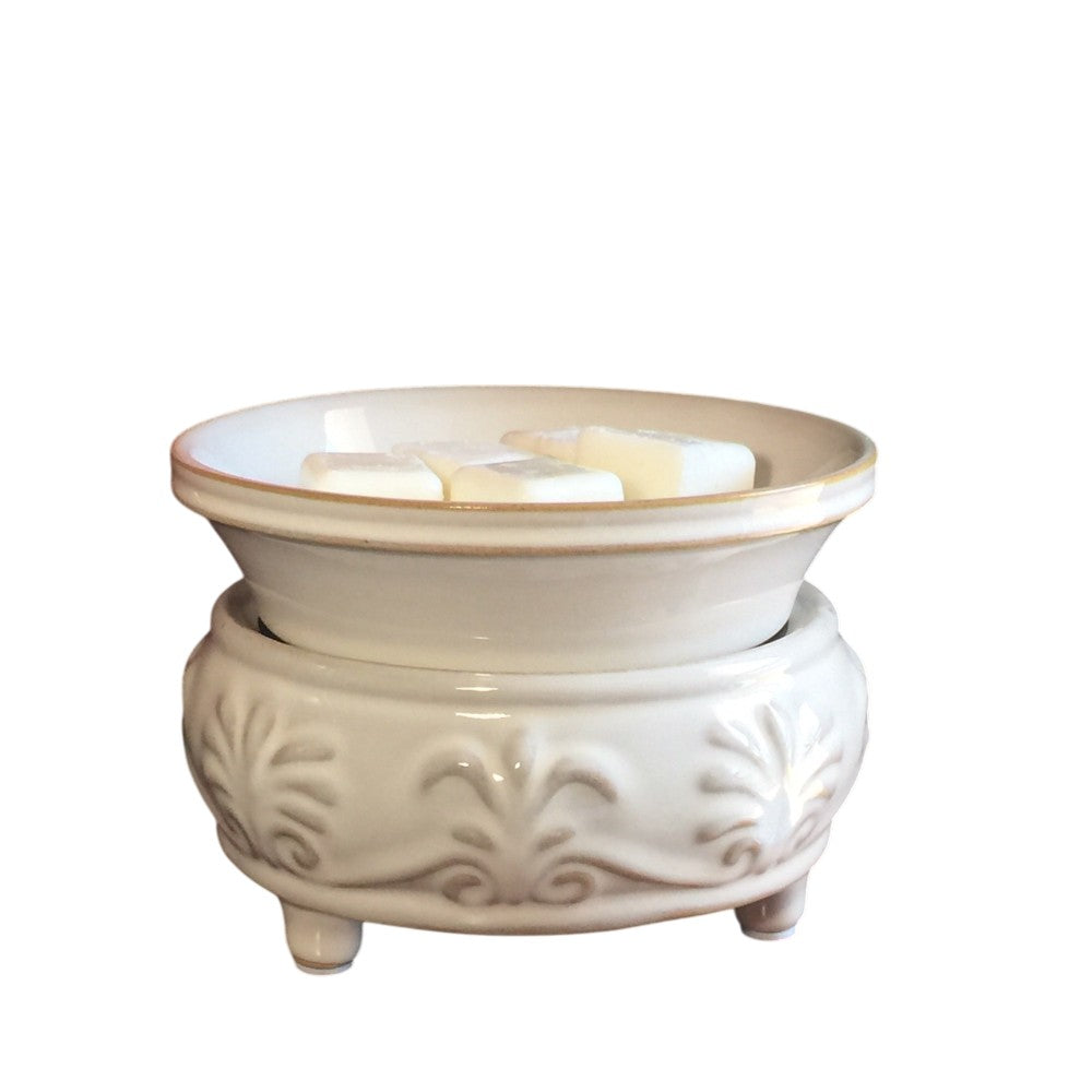 Beige candle warmer with floral details on a white background.