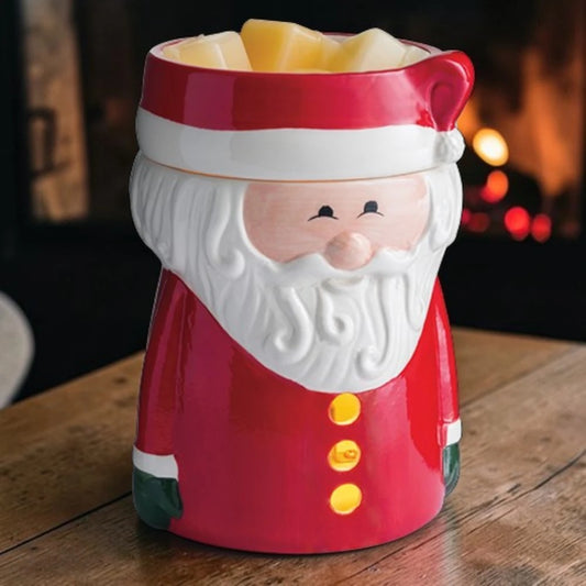 Santa Claus wax warmer on a wooden surface with a fireplace blurred background.