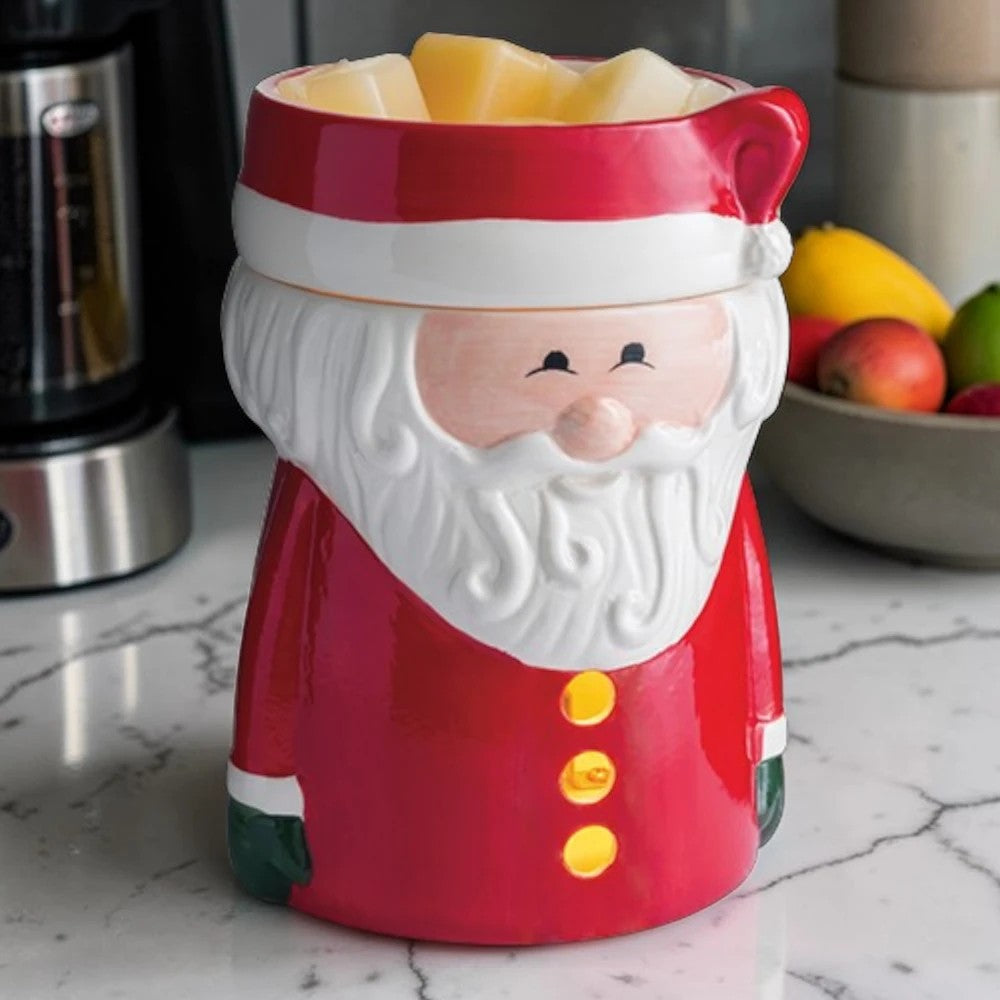 Santa Claus wax warmer on a kitchen counter with a coffee maker and fruit bowl in the background.