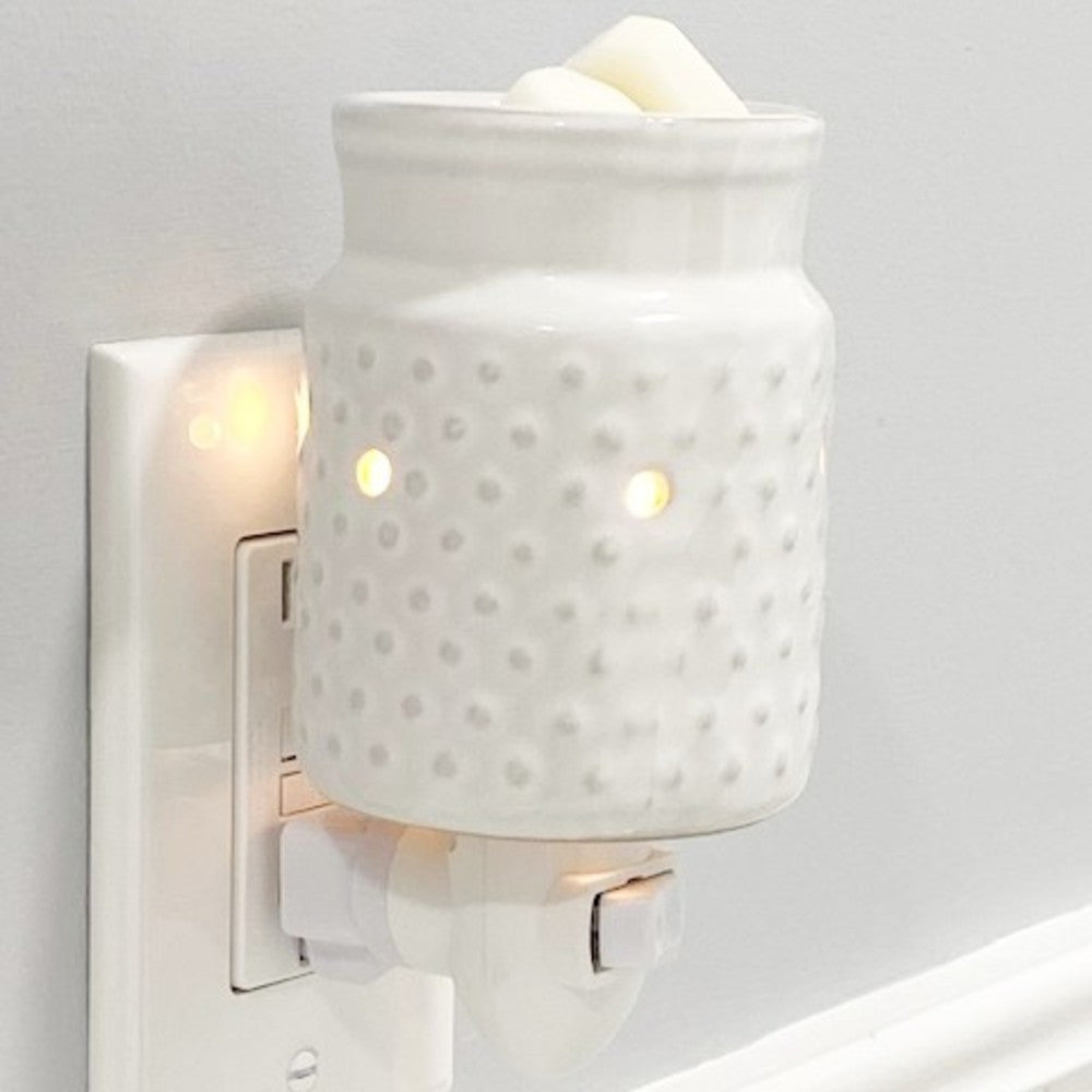 White Hobnail candle warmer plugged into an electric outlet.