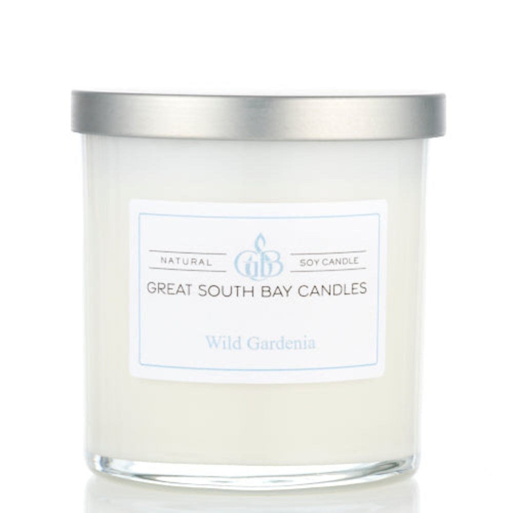 Wild Gardenia candle in a white glass tumbler with a silver lid.