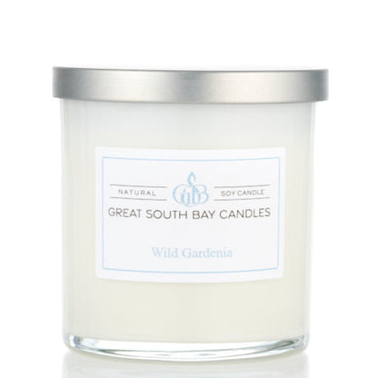 Wild Gardenia candle in a white glass tumbler with a silver lid.
