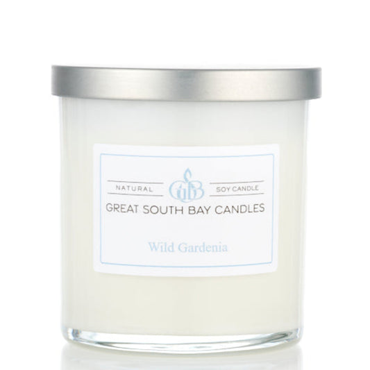 Wild Gardenia candle in a white glass tumbler with a silver lid.